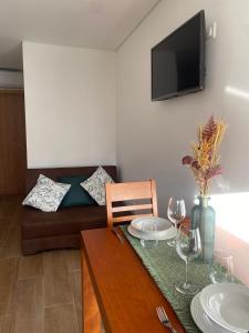 Una sala de estar con un sofá y una mesa con copas de vino. en Quinta do Azibo Studios Bragança, en Bragança