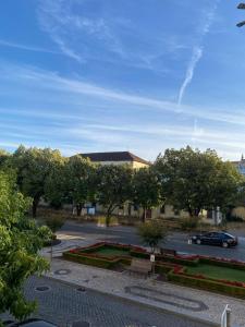Un estacionamiento con un banco y árboles y un edificio. en Quinta do Azibo Studios Bragança, en Bragança