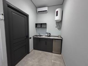 a kitchen with a black door and a sink at Terminal 1 in Pʼarakʼar