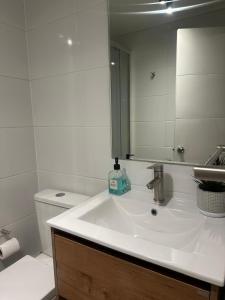 a bathroom with a sink and a mirror and a toilet at Excelente y Central dpto en Distrito Icónico in Los Ángeles