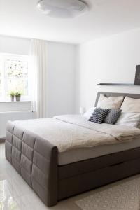 a white bedroom with a large bed with pillows at Ferienwohnung Steuerwald in Bobenheim am Berg