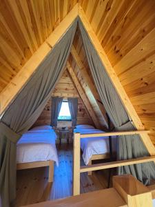 a bedroom in a log cabin with two beds at Durmitor's Mirror Žabljak in Žabljak