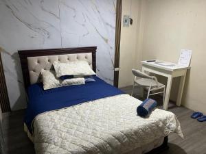 a bedroom with a bed with a desk and a chair at HABITACIÓN CENTRAl in Machala