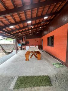 un tavolo da picnic all'interno di un edificio con un'amaca di FLAT - ALUGO POR DIAS - Sua casa de praia te espera! a Balneário Barra do Sul