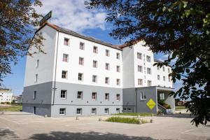 a white building with a red roof at OEKOTEL Traiskirchen in Traiskirchen