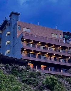 a large building on a hill with its lights on at Sach Naina Residency, Mussoorie in Jāmb
