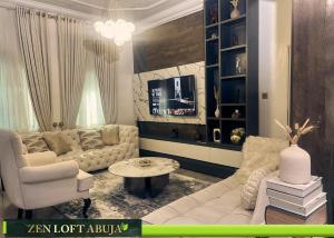 a living room with a couch and a tv at Zen Loft Terrace Maitama Abuja in Abuja