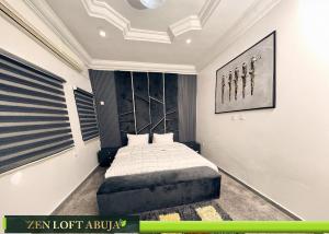a bedroom with a bed and a painting on the wall at Zen Loft Terrace Maitama Abuja in Abuja