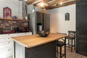 a kitchen with a table with a bowl of fruit on it at Gite La Clef Des Champs - Touraine in Tavant