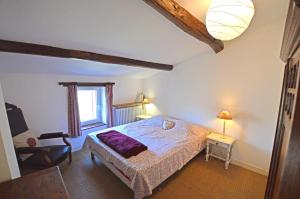 a bedroom with a bed and a chair in a room at Mas de la Sauvagère in Viviers +17 photos