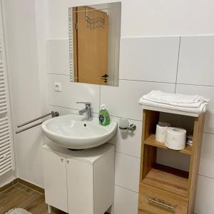 a white bathroom with a sink and a mirror at Maxhaus 1 in Thüngen