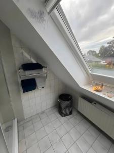 a bathroom with a window and a white tiled floor at Zum Weserstrand in Hagen OT Rechtenfleth