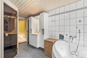 un bagno con vasca e lavandino e una cucina di 10820-Ulfborg-Baekbyvej-113 a Øhuse Altre 20 foto
