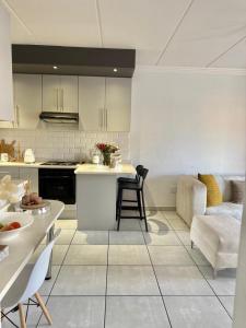 eine Küche und ein Wohnzimmer mit Tisch und Stühlen in der Unterkunft Micasa Su Casa! in Boksburg