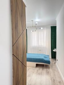 a bedroom with a blue bed in a room at Asel Residential Complex, stylish 3-room apartment in Atyraū +12 photos