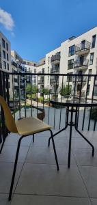 een stoel en een tafel op een balkon met gebouwen bij Good Time Apartments 104 Komfortowy apartament w sercu Starego Miasta in Poznań
