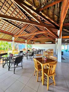 Cupe Beach Living Resort By Flatbpaiva في بورتو دي غالينهاس: مطعم بطاولات وكراسي وسطح