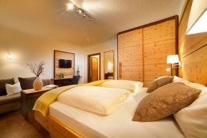 a bedroom with a large bed and a couch at Hotel Bergblick in Scheidegg