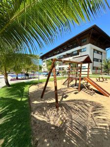 Cupe Beach Living Resort By Flatbpaiva في بورتو دي غالينهاس: ملعب على الشاطئ مع مبنى