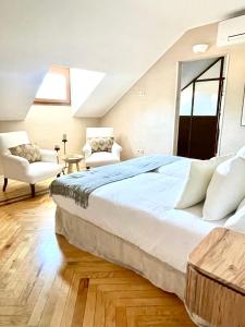 a bedroom with a large bed and two chairs at El Torreón de Cepones in Segovia