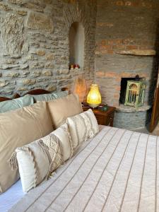 a bedroom with a bed and a stone wall at Şirince Kirke Otel in Sirince +25 photos