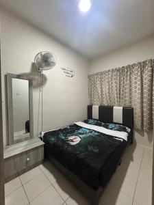 1 dormitorio con cama, espejo y ventilador en Harry Potter Homestay Cameron Highlands, en Tanah Rata