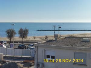 einen Blick auf das Meer von einem Gebäude mit einem Parkplatz in der Unterkunft Les Alizes in Le Grau-dʼAgde