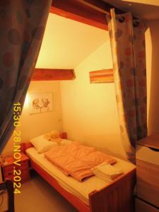 ein kleines Schlafzimmer mit einem Bett mit Vorhang in der Unterkunft Les Alizes in Le Grau-dʼAgde
