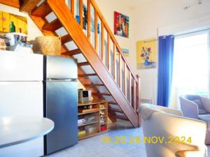 ein Wohnzimmer mit Kühlschrank und Treppe in der Unterkunft Les Alizes in Le Grau-dʼAgde