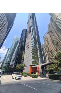 a white car parked in front of a tall building at Sky suites klcc by Elham in Kuala Lumpur