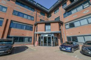 Un coche aparcado delante de un edificio de ladrillos en Large Luxury Studio Apartment, en Saint Albans