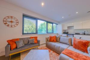 Una sala de estar con dos sofás y una cocina. en Large Luxury Studio Apartment, en Saint Albans