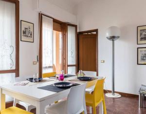 a dining room with a white table and yellow chairs at Lakeview loft in Rivoltella +4 photos