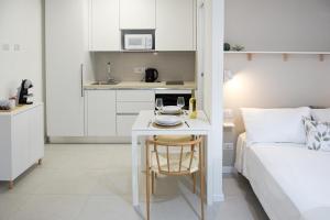 Quartu Sant'ElenaにあるPoetto Studio, Private Parking, SmartTV, Park Viewのベッド、テーブル、キッチンが備わる客室です。