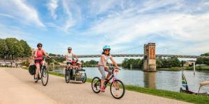 three people riding bikes in front of a bridge at Le Toué, Charme and Voie Bleue 