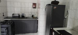 a kitchen with a black refrigerator and a stove at Cozy Kitnet on Costa Beach in Vila Velha