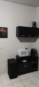 a room with a white wall and a microwave at Cozy Kitnet on Costa Beach in Vila Velha