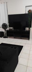 a living room with a black couch and a plant at Cozy Kitnet on Costa Beach in Vila Velha