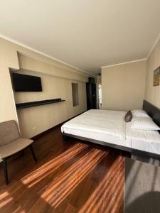 Un dormitorio con una cama grande y una silla. en Shirak Hotel, en Ereván