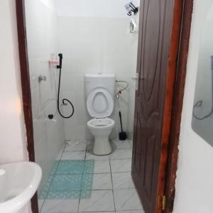 a bathroom with a toilet and a shower and a sink at Watamu Plaza Studio 2 in Watamu
