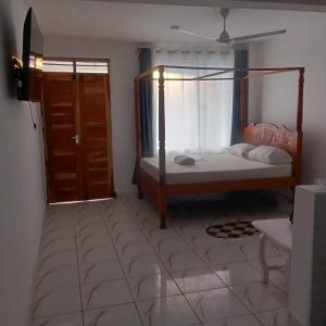 a bedroom with a bed and a window and a door at Watamu Plaza Studio 2 in Watamu