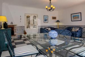 エリセイラにあるCasa os Naias by ACasaDasCasasのリビングルーム(ガラステーブル、青い椅子付)