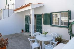 エリセイラにあるCasa os Naias by ACasaDasCasasの家のパティオにあるテーブルと椅子のある部屋