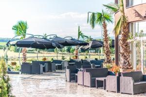 a row of chairs and umbrellas on a patio at Miraj Resort in Lučenec