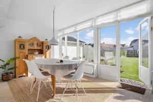 a dining room with a table and white chairs at 70303-Ulfborg-Jagtvejen-4 in Thorsminde +30 photos