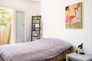 a bedroom with a bed and a bird picture on the wall at Chambre avec entrée indépendante-Jardin privé- 200m des plages in Théoule-sur-Mer