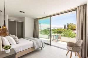 a bedroom with a bed and a large glass window at Villa Bougainvillea Boutique 1 by Villa Plus in Marathias +15 photos