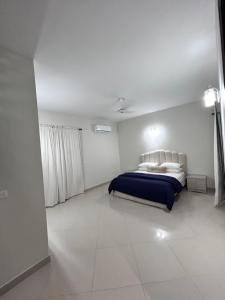 a bedroom with a bed in a white room at Tribal house in Karachi
