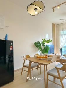 a kitchen with a wooden table and a black refrigerator at Meldrum Heights Muji Creamy House Walks to CIQ in Johor Bahru