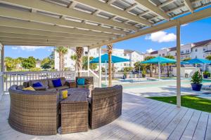 a patio with a couch and chairs under a pergola at Bowen Village 6110 in Charleston